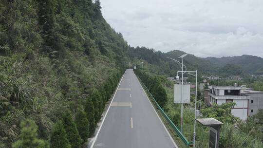 男人骑着摩托车穿过山边公路