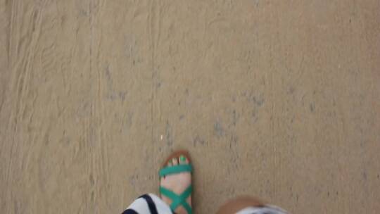 脚在海滩上行走