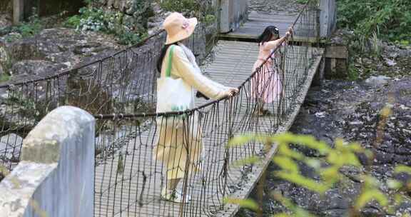 妈妈与女儿在山野吊桥上玩耍