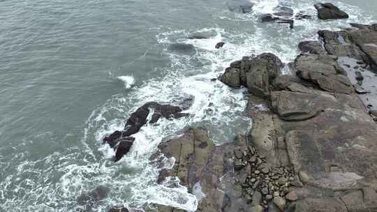 海岸礁石海水拍打礁石阴天海滩岩石海浪冲刷