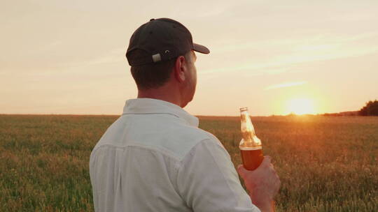 农夫对着自己麦田喝啤酒