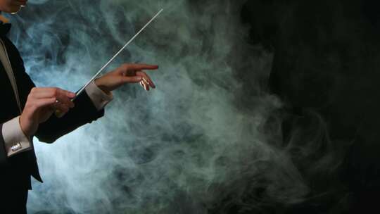 身穿西装的交响乐团指挥正在指挥音乐家，指