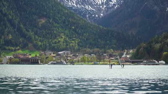 在奥地利的阿琴湖上滑浪风帆。在阿尔卑斯山的水上划船。