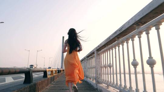 女孩在桥上奔跑的背影慢镜头视频素材