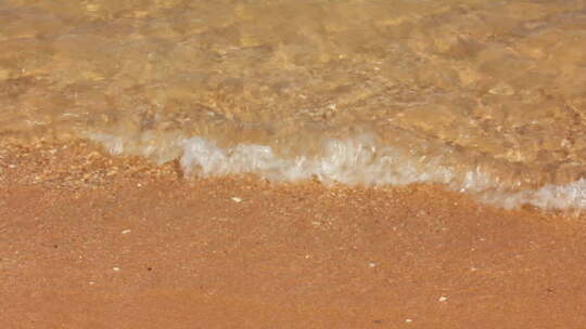 近距离拍摄清澈海浪涌向沙滩