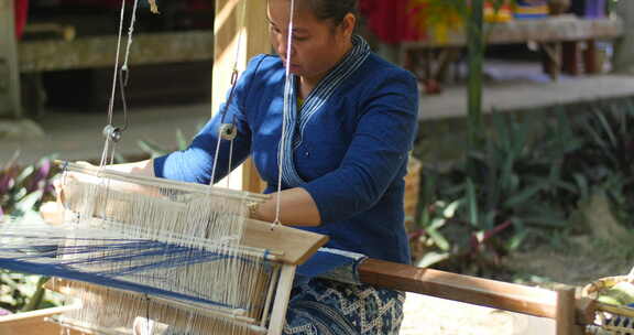 女人在织机上编织丝绸