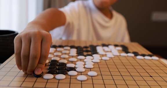 可爱的男孩在窗边下围棋