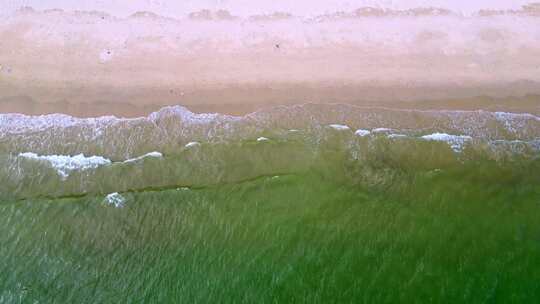 海滨城市高楼边的沙滩和海水景象