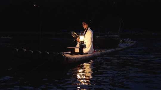 桂林漓江上的汉服美女挑灯翻阅书籍视频素材模板下载