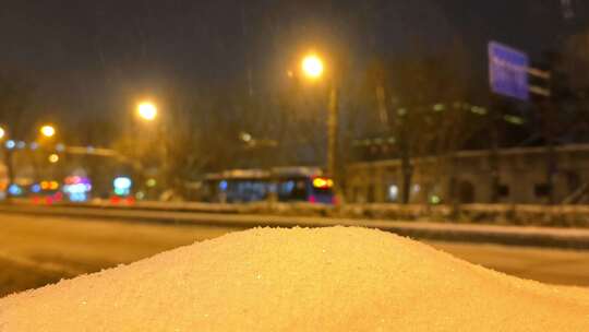 冬季下雪天夜晚路灯下的公路车流