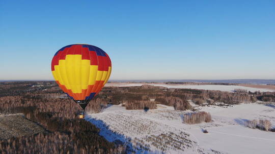 人们乘坐大气球在冬季森林上空飞行