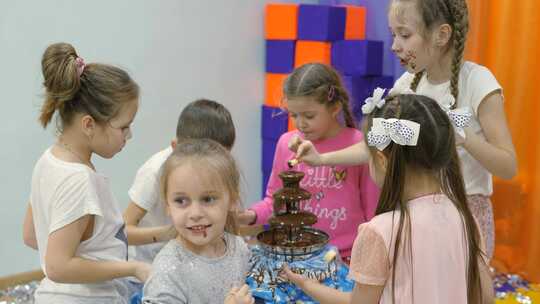 儿童游戏室。孩子们从巧克力喷泉里吃巧克力