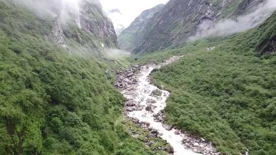 空中镜头飞过喜马拉雅山的一条河流，周围是