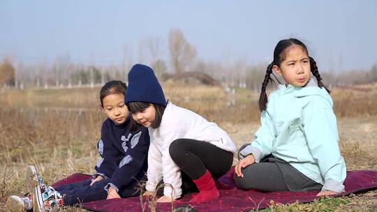 冬季在公园草坪上玩游戏的三个女孩