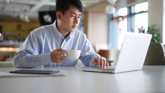 年轻商务人士办公室咖啡时间操控笔记本电脑视频素材模板下载