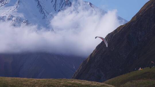 雪山间滑滑翔伞的人视频素材模板下载
