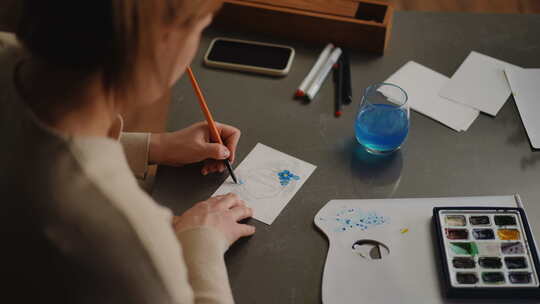一个女人用画笔画了一张母亲节贺卡