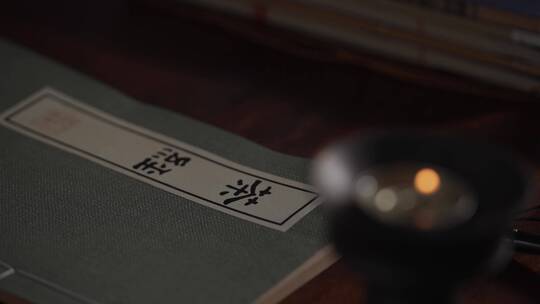 烛光下古代书房书桌上中国古代农学著作茶经