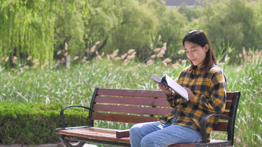 中国女性美女在公园树林看书学习