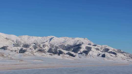 航拍冬季新疆赛里木湖雪山冰湖蓝冰日照金山