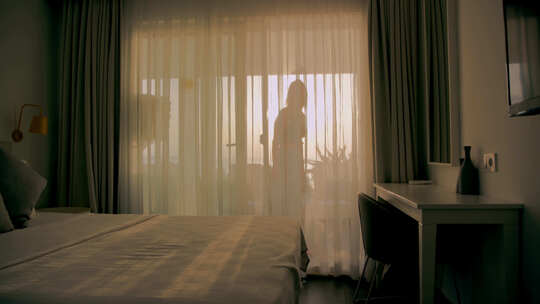 女孩从阳台进入房间，背景是日落视频素材模板下载