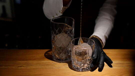 调酒师在玻璃中混合冰