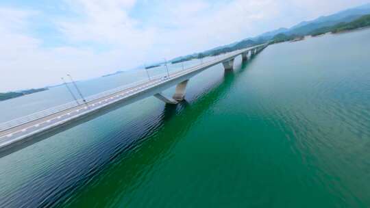 穿越机飞跃湖面大桥跟随新能源汽车