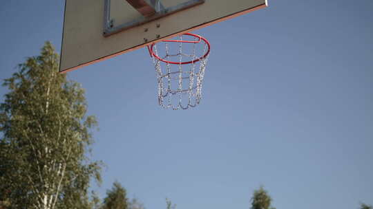 橙色篮球从篮筐上反弹到蓝天后