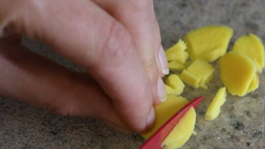 用刀切成小块的新鲜姜根的视频特写。