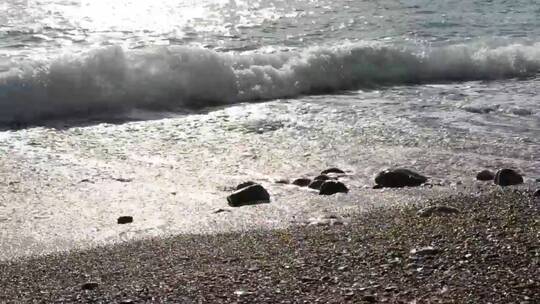 银色的海浪拍打在海滩上