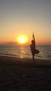 日落时分沙滩上练武术的女子竖屏