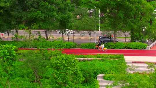 莆田木兰溪行人骑行于城市绿植环绕道路