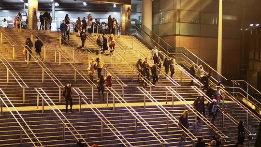 夜晚人们在通往公共交通站台的楼梯行走