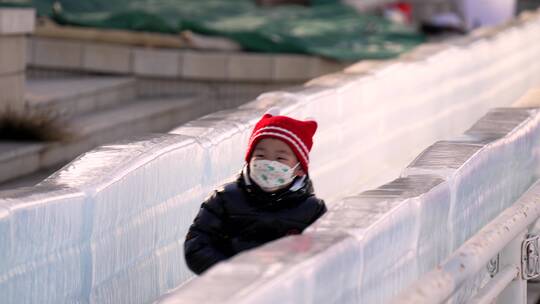 4K升格实拍冬季在冰雪乐园玩冰滑梯的孩子