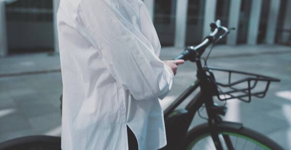 女人搭着自行车在城市街头