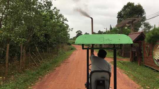 一辆小型车辆在农村地区的未铺砌道路上行驶