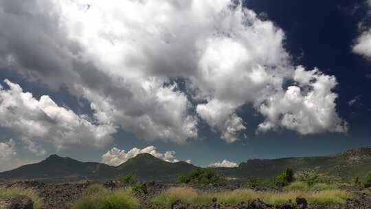 玄武岩石质和茂密平原中的云运动视频素材模板下载