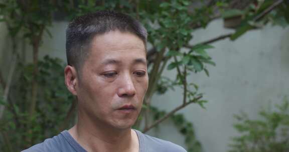 户外男子院子里喝水特写画面