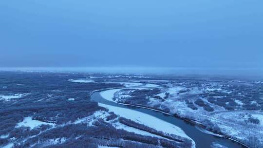航拍晨曦中的雪原河流景观