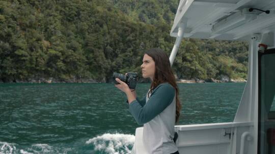 女人拿相机在船上拍照