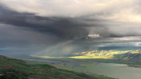 风暴云雨逼近丘陵草甸环绕的湖泊地理视频素材模板下载
