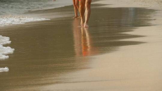 一名赤脚男子在海滩上散步