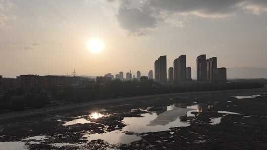 城市夕阳下的高楼与湿地景观