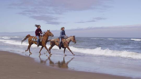 两个女人在海边一起骑马