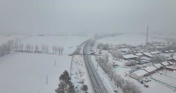 被雪覆盖的村庄及铁路线的冬日景象