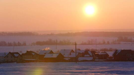日出笼罩着白雪皑皑的小镇风光