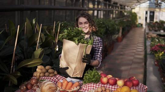 抱着装满蔬菜的袋子的女人