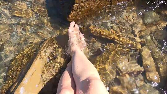 在海水里泡脚的女人腿部特写