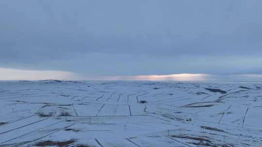 航拍浓郁夕阳下的垦区雪原