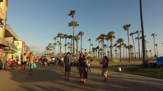 黄昏威尼斯海滩上来往的游客